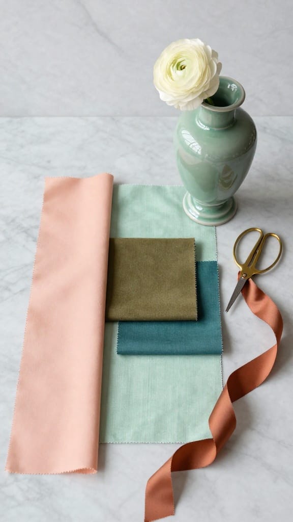 Spring wedding colors 2026 fabric swatches in Peach Fuzz, sage, and teal on marble surface